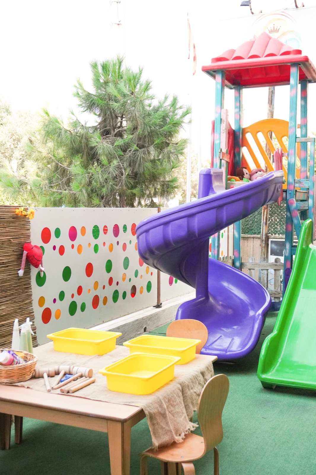 Bahçede kaydırak, oyun parkı ve açık havada kurulmuş etkinlik masası
