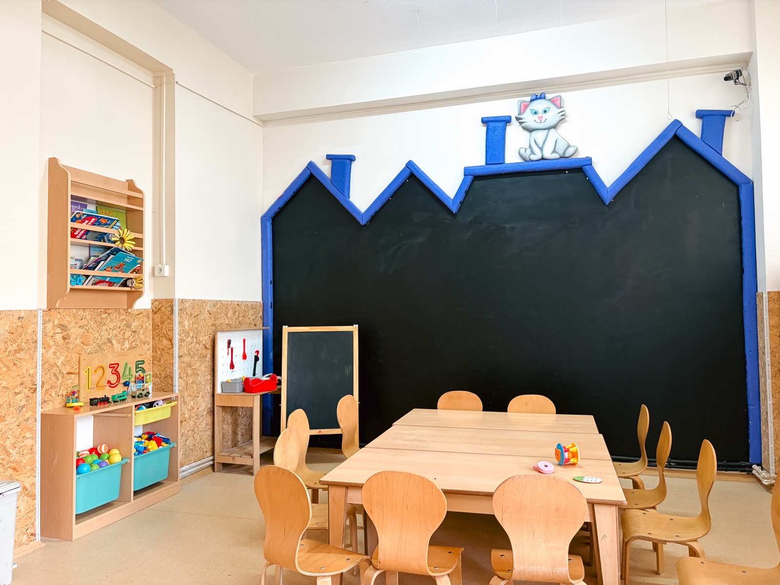 Aydınlık anaokulu sınıfı, kara tahta ve ahşap masalar
